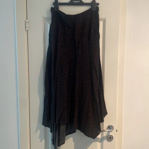 Kjol  - Svart orangeprickig kjol från Kappahl.  Stl 38, bra skick