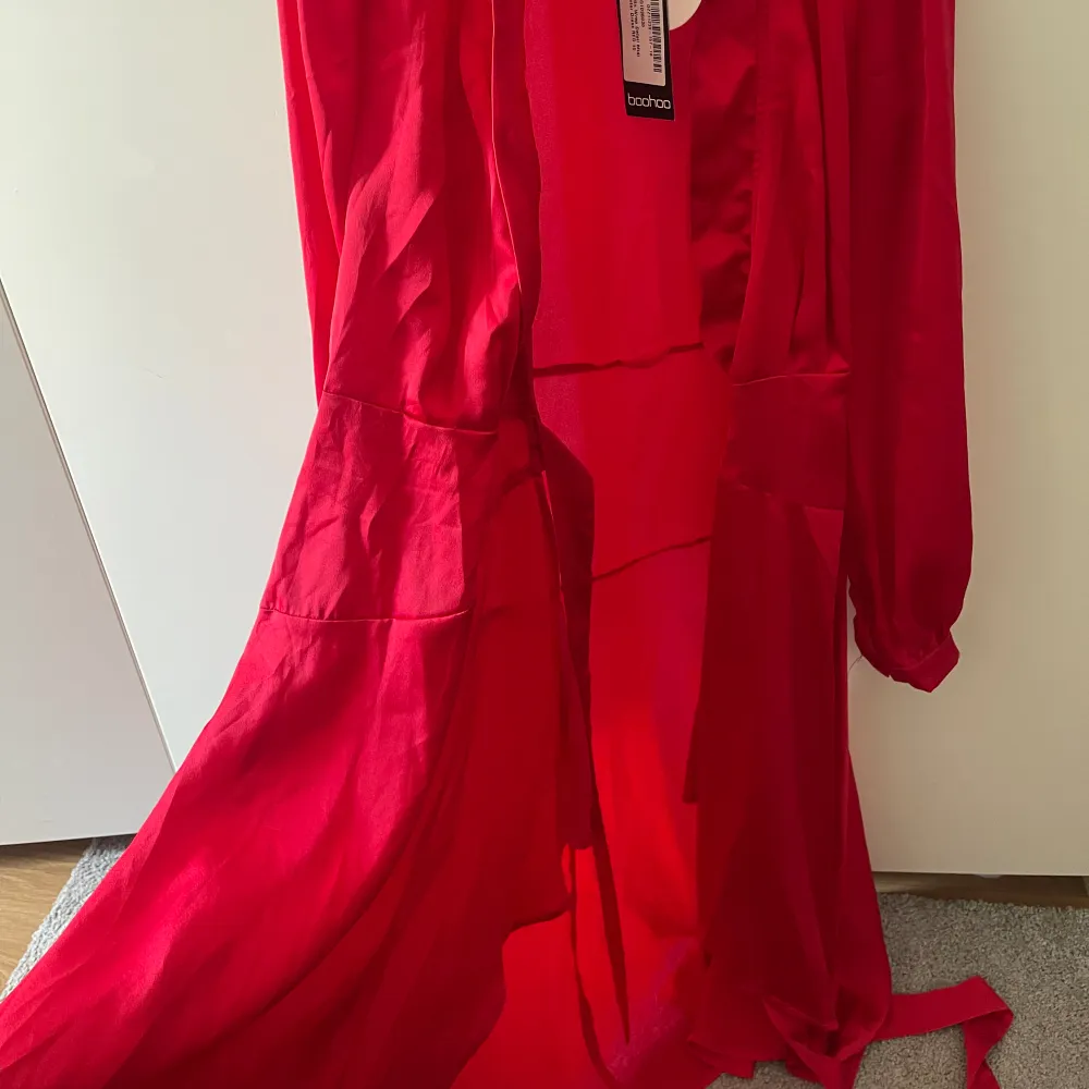 Fin röd klänning från boohoo som man knyter runt midjan, helt oanvänd.. Klänningar.