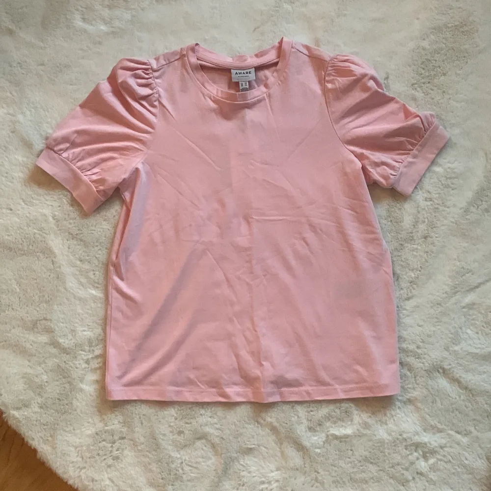 Säljer denna fina rosa t-shirten med puff ärmar. Aldrig använd och lappen sitter kvar💗💗. T-shirts.