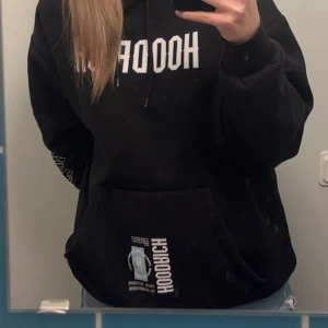 Hoodrich hoodie - Säljer min svarta hoodrich hoodie med tryck ifram, ibak och på armen. Säljer pågrund av att den är lite för lång för mig. Jag köpte den för ca 6 månader sedan men den är som ny. Köpt för 1000kr och säljer för 400-500kr, priset kan diskuteras.