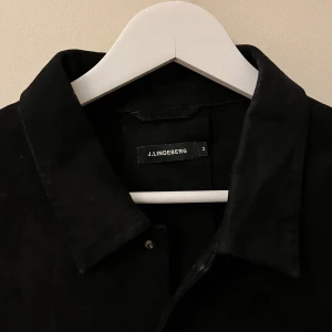 Overshirt j.lindeberg - Sparsamt använd mocka skjorta/overshirt från j.lindeberg storlek M. Lagning har gjorts hos skräddare längst ner på ena armen, inget som är jätte synligt enligt mig. Nypris 3999 kr.