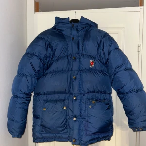 Fjällräven dunjacka - Säljer min fina Expedition down jacket från Fjällräven! Fint skick, köpt på tradera för två år sedan och sparsamt använd av mig 🩷så himla go och varm, hör av dig om du vill ha fler bilder! 🤗gula bandet i luvan saknas men annars 🙌👍