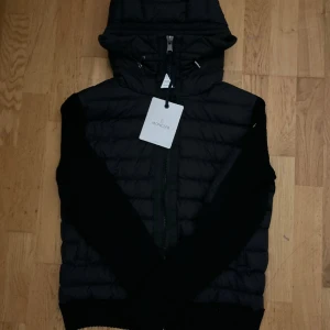 Moncler cardigan  - En svart Moncler cardigan i storlek M och passar S också. har den en dragkedja framtill. Den är enkel att ta på och av, och ger en stilren och avslappnad look. Perfekt för att hålla dig varm och bekväm samtidigt. Pris kan diskuteras