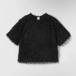 Glittrig topp - Jättefin svart topp med fransar och lite glitter, som passar perfekt till fester eller nyår. Endast använd en gång så i jättefint skick. Storlek 164 men passar XS/S.