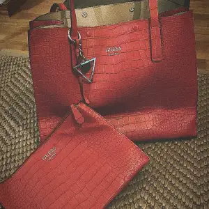 Stor röd guess väska som kommer med en mindre den ser helt ny ut och köptes för 2000kr
