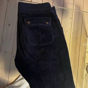 Juicy Couture mjukisbyxor strl XS - Säljer mina mörkblå juicy couture byxor med gulddetaljer i storlek XS. Byxorna är använda men fortfarande i fint skick. 