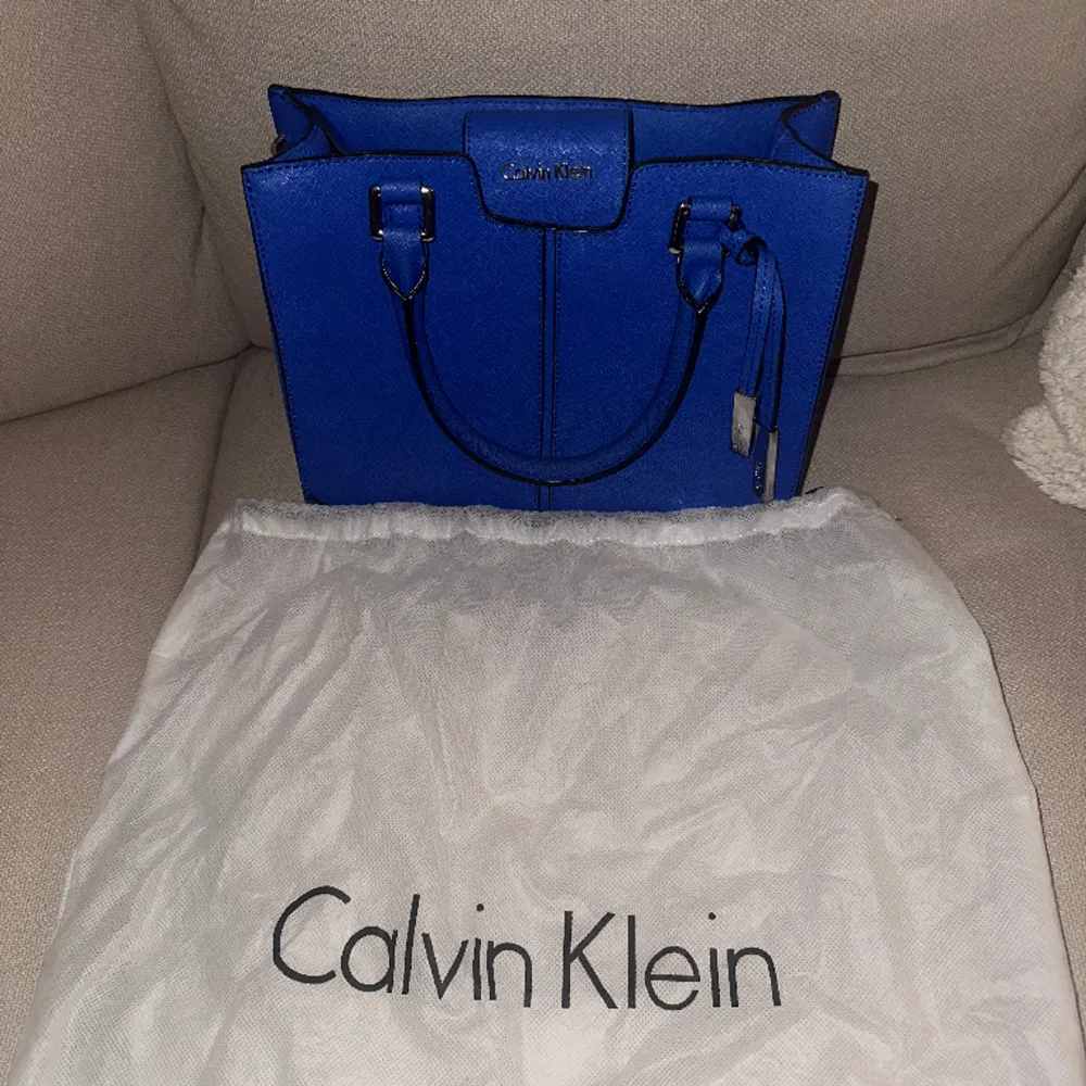 Blå väska från märket Calvin Klein. Helt felfri/knappt använd, insidan av väskan är fläckfri. Köpt i Newport california, USA i CK butik. . Väskor.