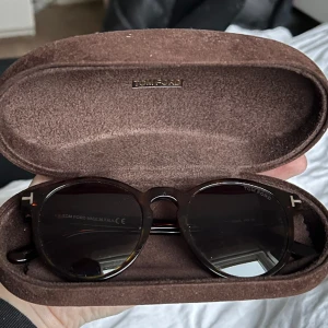 Tom Ford solglasögon  - Solglasögon från Tom Ford.  Bruna med blå ish glas.  Sparsamt använda.  Inga stora repor osv!  Nypris cirka 2,500 kr  Fodral och originalbox samt alla små papper och putsduk följer med!