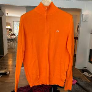 Halfzip pullover i skitsnygg orange nyans från j.lindeberg. Storlek m för herr, oanvänd.