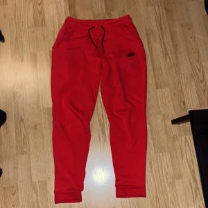 Röda Nike tech byxor  - Knappt använda röda Nike tech byxor väldigt sköna, använt ett par gånger säljer för de får ingen användning!
