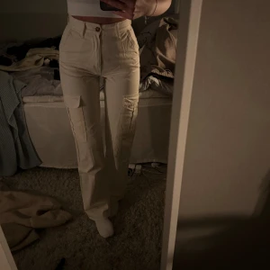 Cargobyxor - Krämvita/antikvita cargopants från stradivarius i storlek 34. 