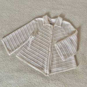 Vintage stickad cardigan / bolero - Otroligt vacker vit stickad cardigan. Köpt vintage, men har inga som helst tecken på användning. Pärlknapparna har tappat lite färg, i övrigt utan anmärkningar. Storlek M men passar såväl XS-M.