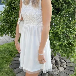 Vit klänning / studentklänning  - Säljer min superfina studentklänning. Använd endast på studentdagen men är i gott skick. Jag är 169 cm lång och klänningen är i storlek 34. Ordinare pris är 700kr säljer den för 320. 
