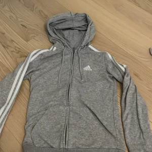Adidas zip up - Grå zip up hoodie från adidas. b Bra skick den ända defekten kan ni se på bild tre.
