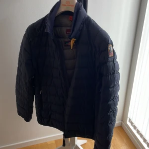 Parajumper jacka, marinblå - Storlek ungdom large. Riktigt bra skick 9/10 inga hål eller fläckar. 