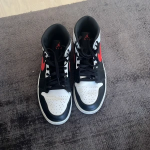AIR JORDAN 1 MID BLACK CHILE RED WHITE - Hej, säljer mina Nike Jordan då jag inte använder de längre. Storlek 45,5. Inga skråmor eller liknande och använda endast fåtal gånger. 