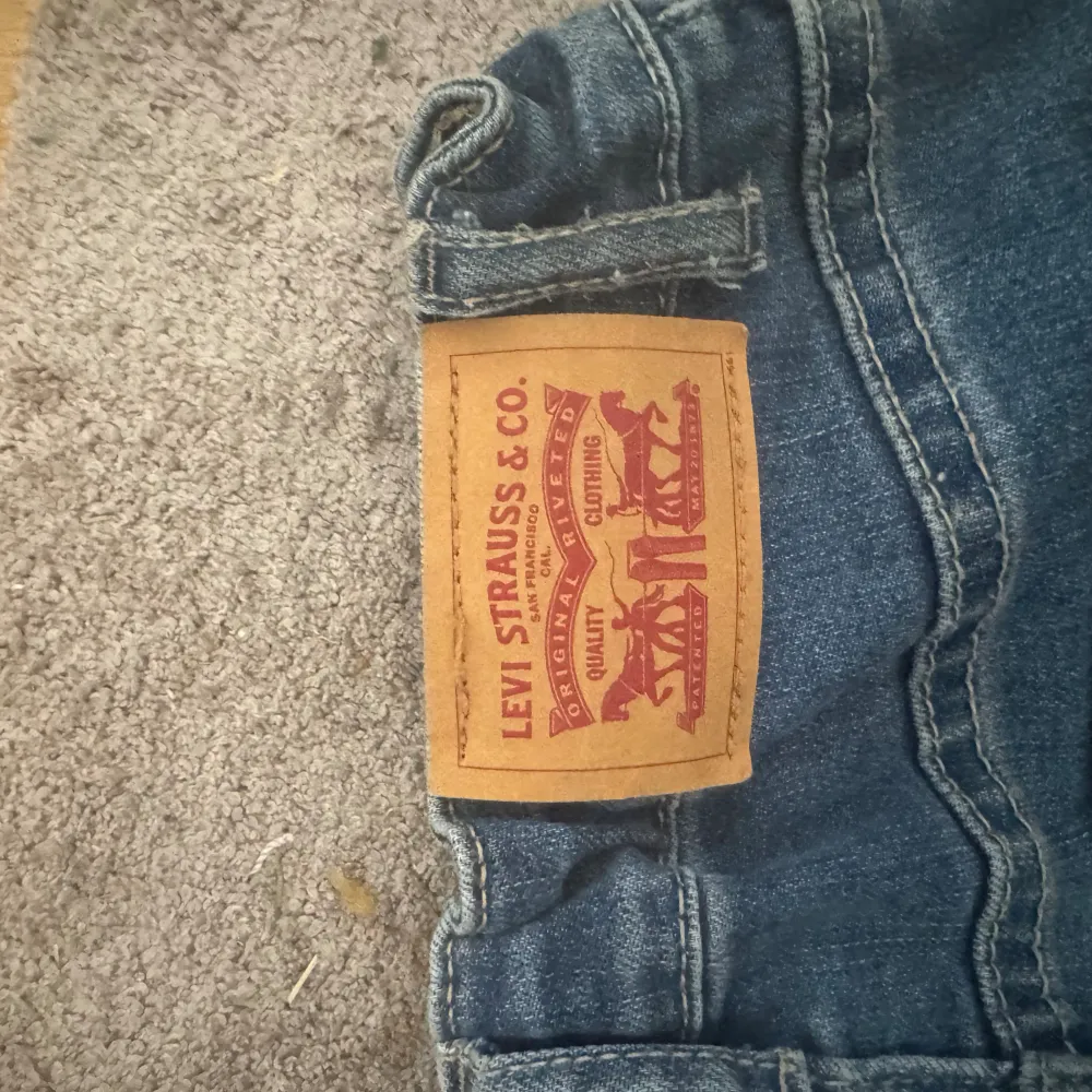 Säljer denna Levis jeans då de är för små för mig, ett av spännena har lossnat,. Jeans & Byxor.