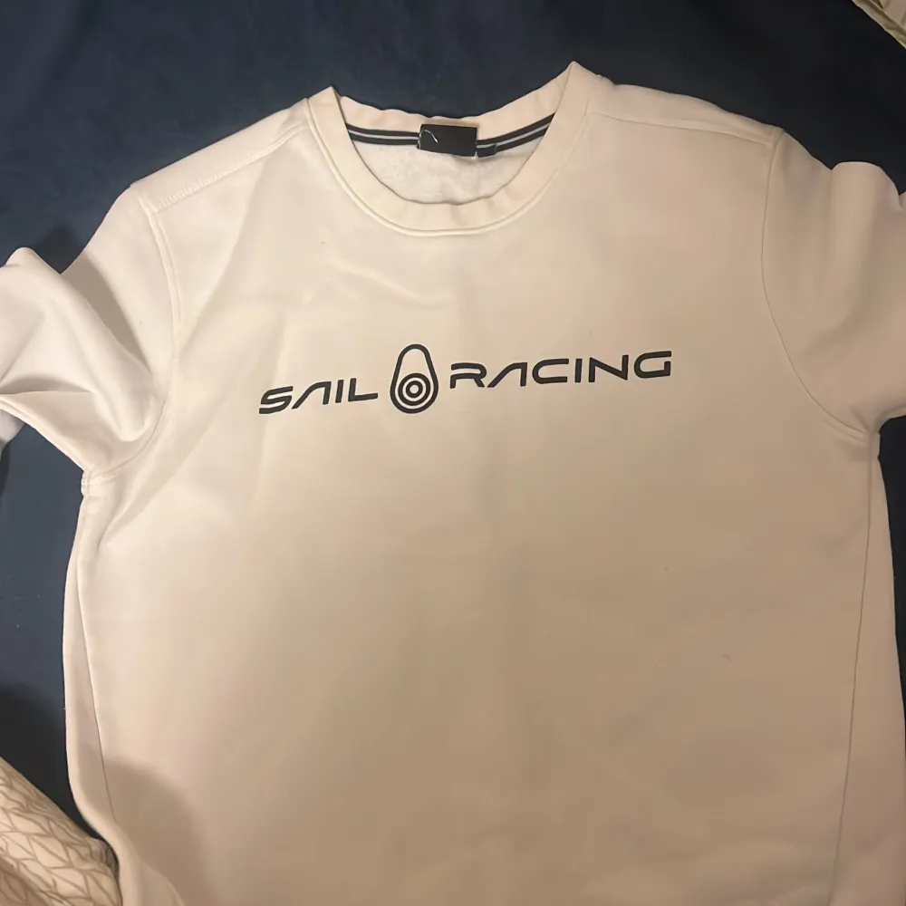 Den är vit med svarta bokstäver på Sail racing tröja som är exakt ny. Tröjor & Koftor.