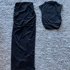 Svart set Kjol och Topp - Säljer detta svarta set med en kjol och topp från shein då det var för stort för mig Aldrig använt, mycket bra skick Kjolen har även en slits baktill