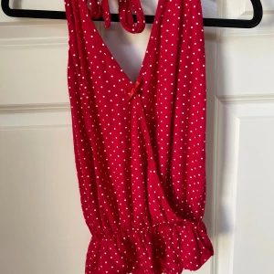 Röd Halterneck topp stl M - Röd halterneck topp med vita prickar i storlek M, passar även S Knappast använd i bra skick utan några defekter