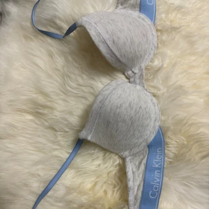 Calvin Klein bh 70A - Storlek 70A, superfint skick. Ljusblå grå och vit bh. Går att justera med banden. För liten för mig. Knappt använd