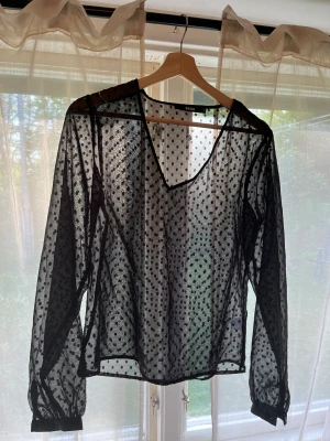 Blus - Jättefin svart genomskinlig blus med prickar på, knappt använd och i nyskick.