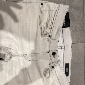 Dondup jeans - Ett par fräscha dondup jeans i modellen George. Storleken är 30 och dem är i en väldigt ljus grå färg. perfekta nu till sommaren. Det är den senaste kollektionen av George, finns en defekt inget man ser men värt att tillägga. Den är där bältet sitter