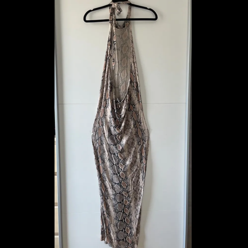 Snake print PLT maxi halterneck klänning med öppen rygg. Otroligt attraktiv på kroppen. Köptes hösten 2022 och jag har använt den 2 gånger. Jätte bra skick. Obs. Kan tvättas och strykas om önskas 🤗. Klänningar.