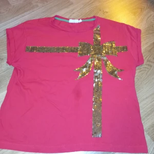 Röd jul T-skirtst  - Den är använd 1 gång  I fint skick, alla pärlorna sitter kvar! Är storlek 158/164 men sitter som en S/XS Kan skicka fler bilder privat! (Gäller alla mina utlägg)