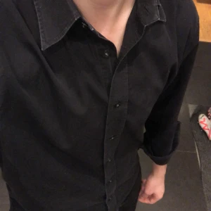 Tiger of sweden skjorta - Härlig Tiger Of Sweden skjorta som är svart men i vissa ljus mörblå då det snyggaste med den är en mindre synlig urtvättnad. Storlek L men passar lika bra M. Kom med frågor!