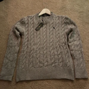 Grå Ralph Lauren tröja - Säljer en stickad ralph lauren tröja i nyskick med tags kvar. Tröjan är varm och skön nu till vintern. Skriv privat om ni har frägor/prisförslag. (Fri Frakt!)