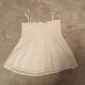 Volang topp - Super fin vit volangtopp från gina tricot, helt ny endast testad men lappen är inte kvar! Man kan även ta av banden så att det blir en tubtopp.🫶🏻
