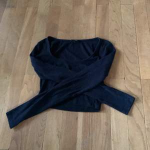 En svart långärmad tröja i ribbat material med en större urringning,. Från monki i stl s.
