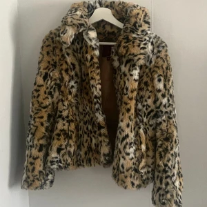 Leopard pälsjacka  - Pälsjacka i leopard mönster. Köpt secondhand men tyvärr aldrig använd. (Jackan är ej ojämn eller sen utan den hänger lite snett bara)