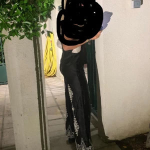 Zara byxor - Jätte fina byxor i matrial av tyyyp satin med fint vitt mönster på av brodyr. Storlek S