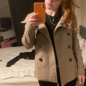 Kort kappa - Säljer nu denna korta brun/beigea kappan! Bra skick! Storlek 38 passar S och M. Hör av dig vid frågor eller om du vill ha fler bilder💕💕