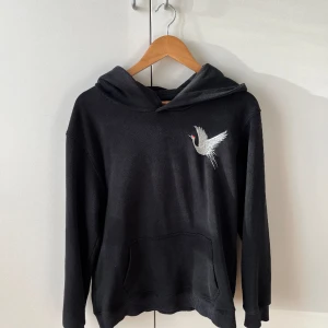 Svart hoodie  - Svart oversized hoodie i storlek S med broderi på ryggen