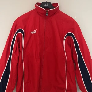 Puma trackjacket - Fräsch röd trackjacket från Puma. Liten svart fläck vid höger ficka annars inga defekter. Möts upp i malmö och fraktar:)