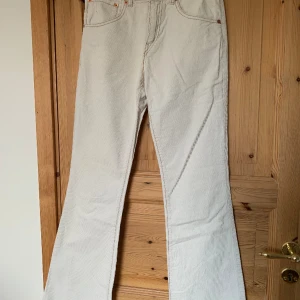 Bootcut manchesterbyxor från Levi’s - Vita manchesterbyxor med utsvängda ben från Levi’s. Köpta second hand, aldrig använda av mig då de är för små. Små bruna fläckar vid höger bakficka, inte testat att tvätta bort dessa. Annars jättefint skick. Mått skickas på begäran!