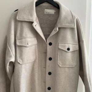 nelly kappa  - bra skick, säljer då den inte kommer till användning, knyte i midjan. beige. passar strl 34 - M