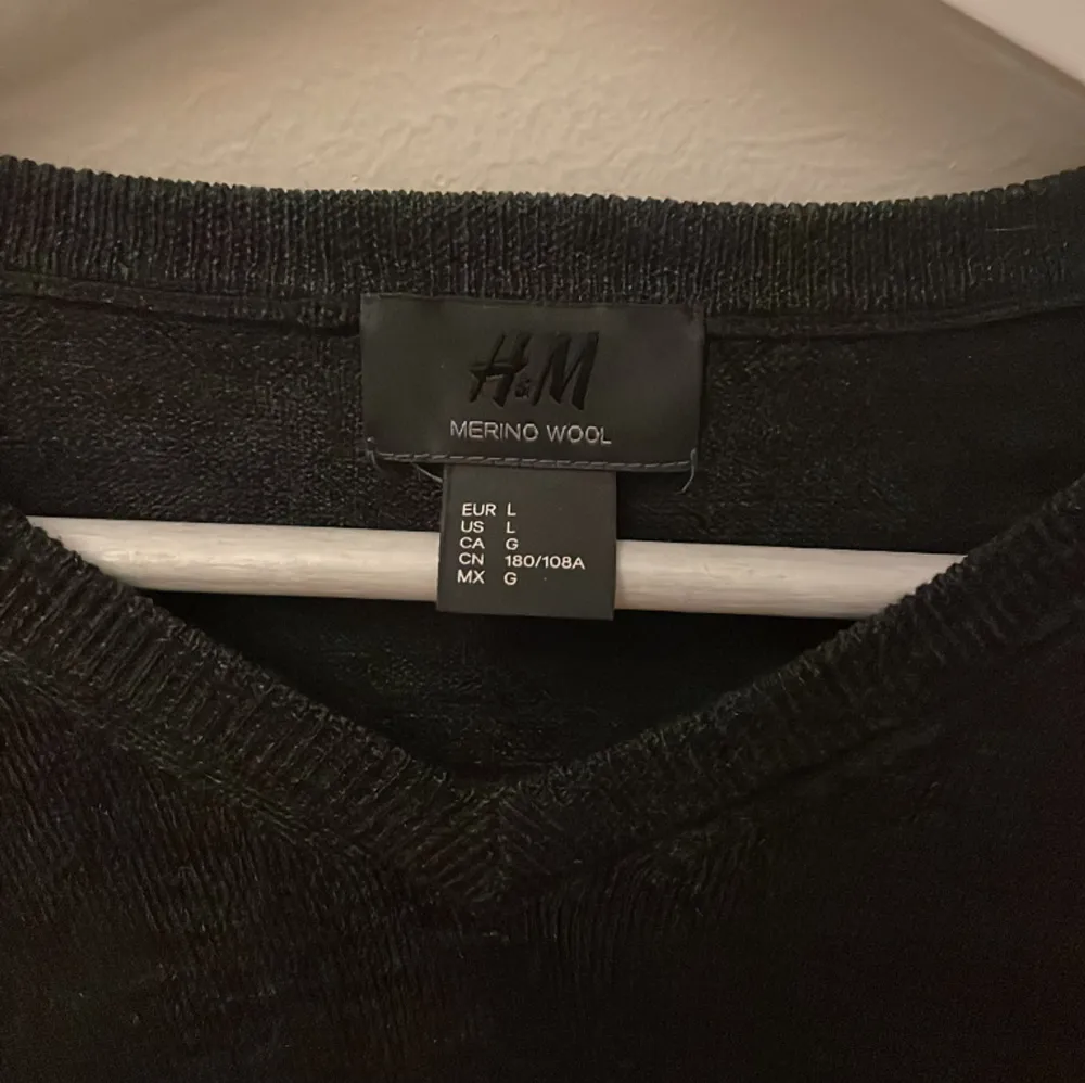 En mörkgrå merinoulls sweatshirt från HM i storlek L med V-ringad krage, inga defekter finns! Den är i väldigt bra skick!. Stickat.