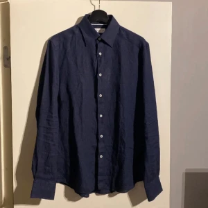 Linneskjorta storlek M mörkblå  - Säljer denna linneskjorta som är ny och oanvänd! Prislappen är dessutom fortfarande kvar. Nypris och köpt för 899 kr. Vid snabba affärer kan självklart priset justeras! 