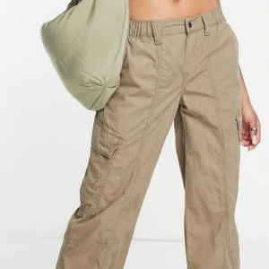 Cargobyxa oanvänd  - Säljer ett par cargo byxor från ASOS i storlek 42 PETITE, vilket få gör dem lite mindre i storleken vilket jag missade, endast provad och glömde skicka tillbaka Lite skrynklig då den bott längst in i garderoben i en påse sen dess🥲