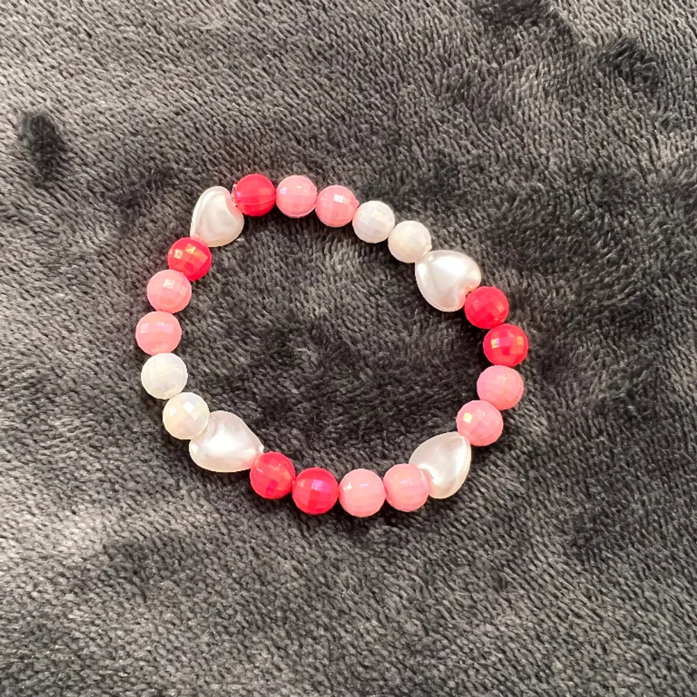 Egentillverkat armband med rosa och vita discokulor 🪩 och vita hjärtan. Är gjort med gummitråd och är ca 17 långt.. Accessoarer.