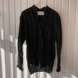 Our Legacy Skjorta - Mörk skjorta från Our Legacy tillverkad i 55% linne, 45% bomull. Väldigt luftig och skön. Storlek 48 ( Medium herr), lite längre där bak än fram. Funkar såklart bra till dam också.  Använd men i väldigt bra skick. 