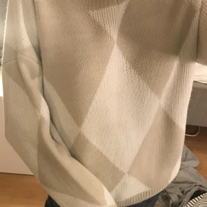 Stickad tröja - Jättegosig stickad tröja med vita och beiga rutor! Köpt på loppis men inga defekter!