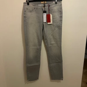 Gråa jeans  - Hej, säljer ett par helt nya oanvända jeans med tagg kvar, köpt hos Cambio. Säljer dessa för jag har bytt still och dessa byxor aldrig kom till användning
