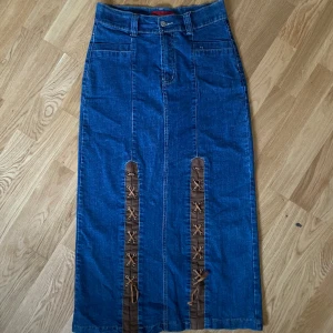 Jeanskjol y2k med snörning  - Super snygg jeanskjol från början av 2000 talet med coola snörnings detaljer fram! Fint skick, hittar inget att anmärka på. Strl S. Mått: Midja-74 cm, Längd-90 cm Kan mötas upp i centrala stockholm 💞