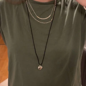 Långt halsband  - Säljer nu mitt finanlånga halsband. Med justerbart svart band med ett silverfärgat hjärta!💕