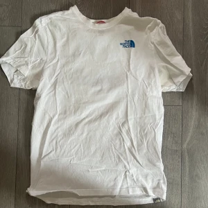 The North Face T-Shirt - Tja! Slänger upp denna T-shirt då den inte kommer komma till användning denna sommar. Har varit favoriten i garderoben länge! Sköna blåa detaljer som passar fint till både jeans och linnebyxor! Storlek M! Hör av er!!